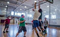 Group of students playing basketball indoors