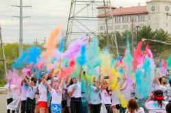 Group of students throwing up different colored powder at the Red Hawk Run