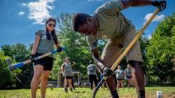 Two students take turns digging a hole