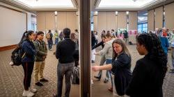 Many of the nearly 200 student researchers are shown explaining their research posters.