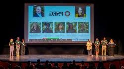 Seven people stand on stage in front of a large screen with the acronym PSEG and photos of team members.