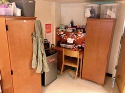 A student's desk and minifridge in a Blanton Hall Triple.