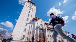 Student walking toward the University Hall tower